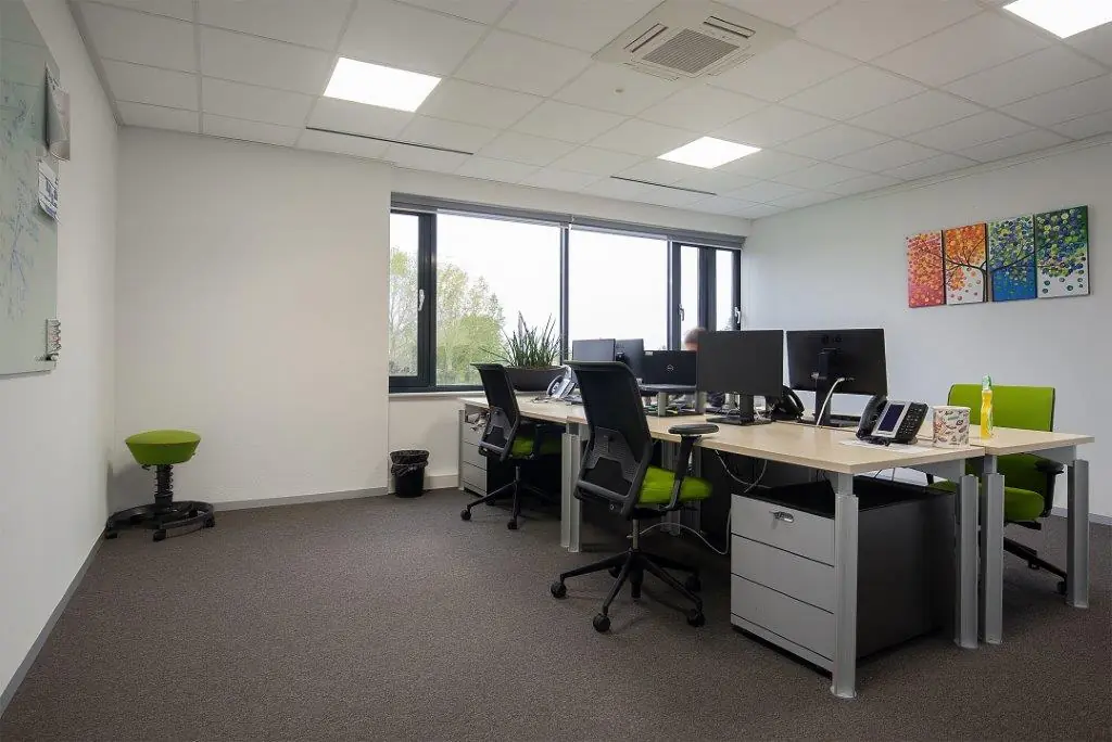 Modern kantoor met werkplekken, groene bureaustoelen en grote ramen aan de Cypresbaan.