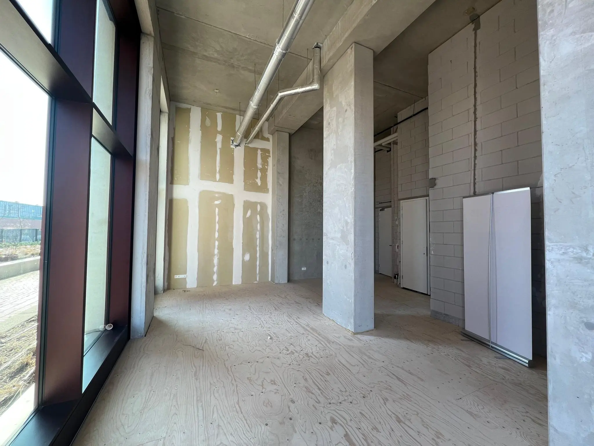 Leegstaand casco winkel- of kantoorruimte met hoge plafonds en grote ramen aan het Maanplein.