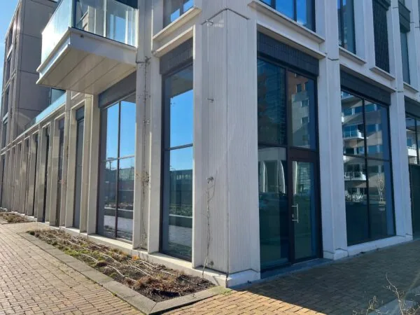 Moderne gevel van een kantoorpand aan het Maanplein met grote ramen en een glazen balkon.