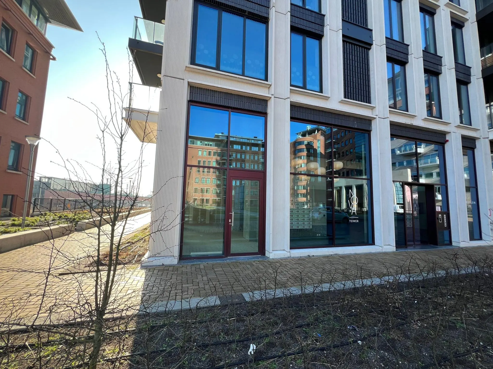 Voorgevel van het appartementencomplex NOA Tower aan het Maanplein met grote ramen en een glazen entree.