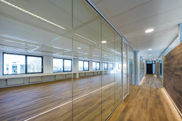 Moderne kantoorruimte aan de Prof. W.H. Keesomlaan met glazen wanden en houten vloeren.