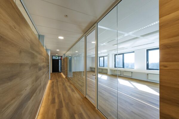 Moderne kantoorruimte aan de Prof. W.H. Keesomlaan met glazen wanden en houten vloer.