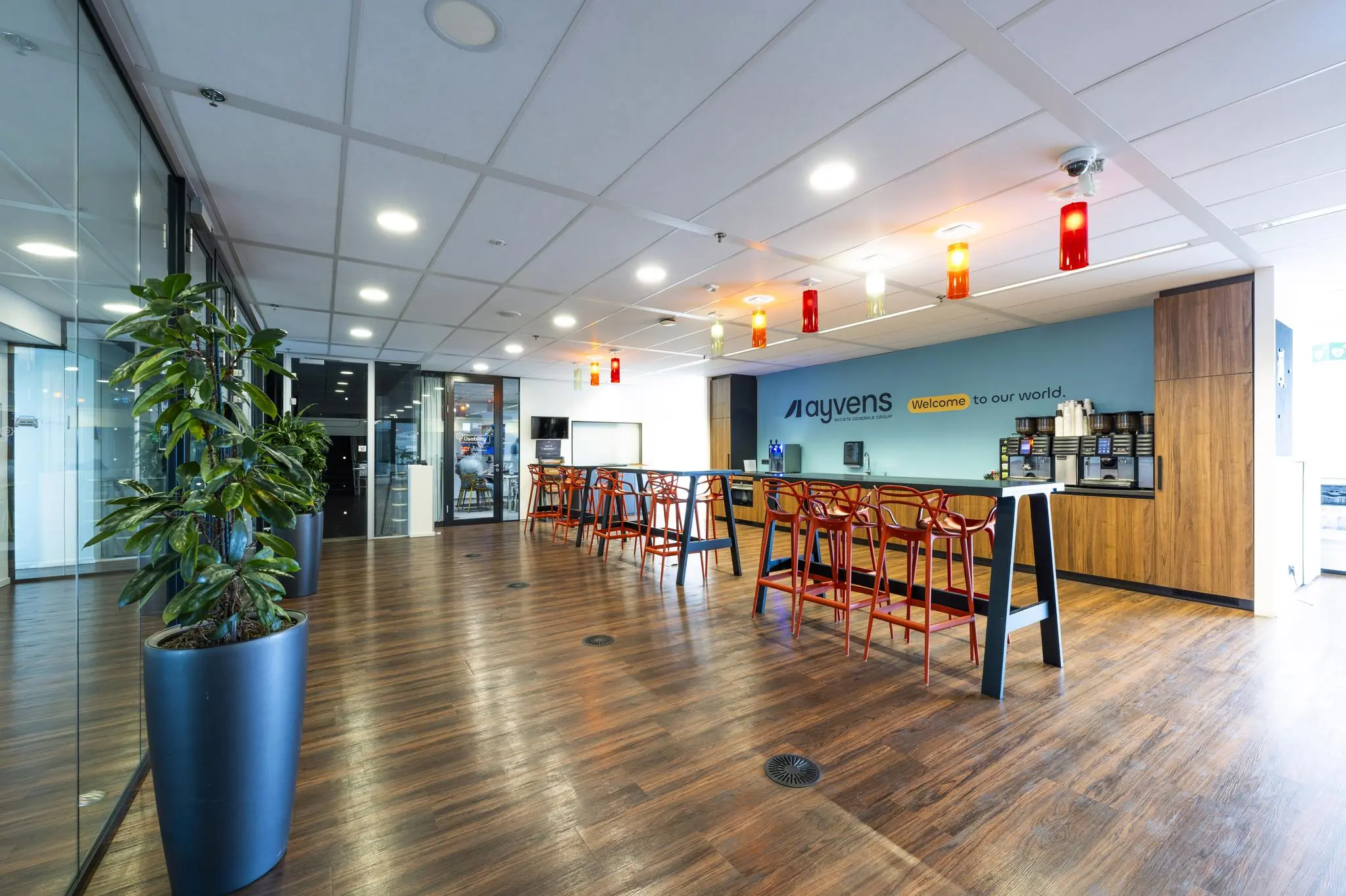Moderne kantoorruimte aan de Johan Huizingalaan met een koffiecorner, zitgedeelte en branding van Ayvens op de muur.