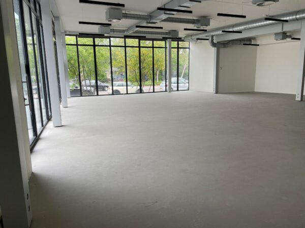 Leeg kantoorpand met betonnen vloer en grote ramen aan de Fred. Roeskestraat.