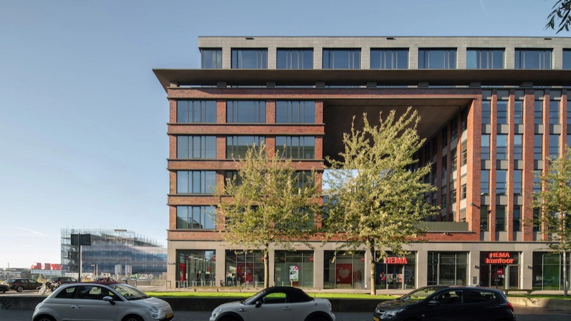 Kantoorgebouw aan de Mt. Lincolnweg met HEMA-kantoor op de begane grond en geparkeerde auto's op de voorgrond.