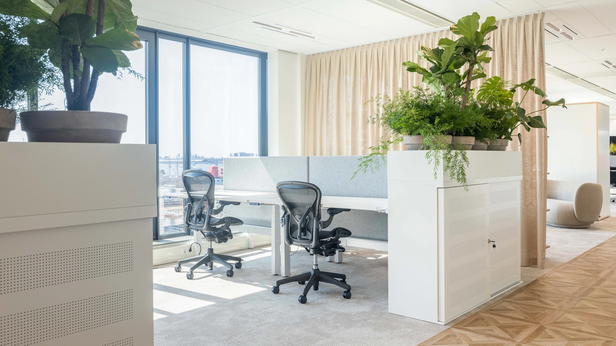 Licht en modern kantoorinterieur aan de Mt. Lincolnweg met werkplekken, ergonomische bureaustoelen en veel groen.