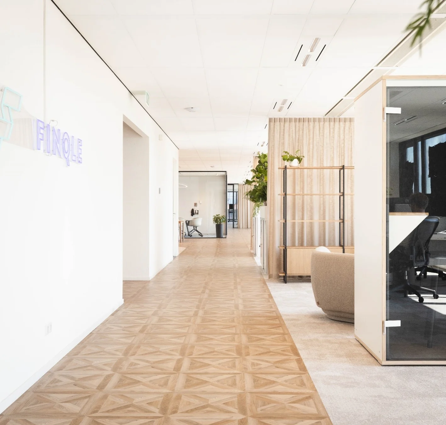 Lichte en moderne kantoorruimte aan de Mt. Lincolnweg met een houten vloer, glazen werkruimtes en groene planten.