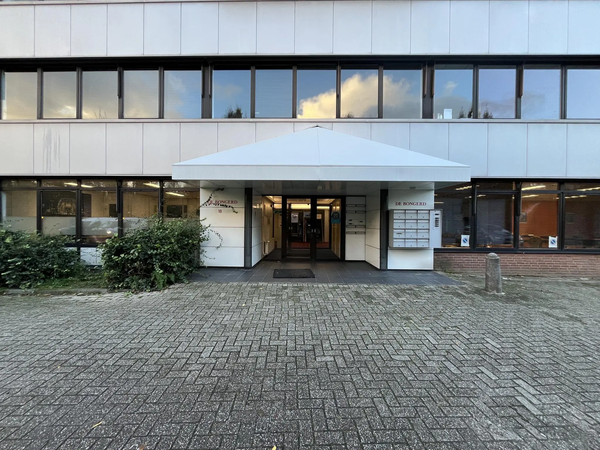 Ingang van het kantoorgebouw De Bongerd aan de Industrieweg met brievenbussen en naamplaat bij de entree.