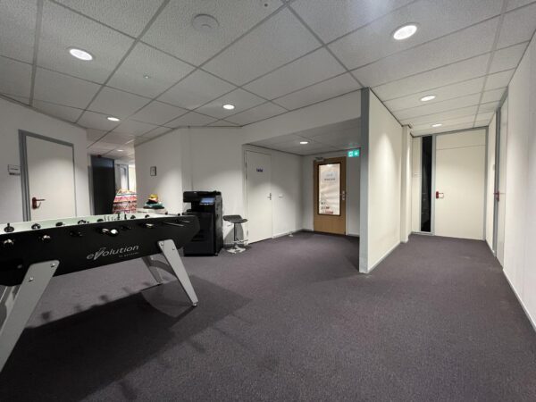 Kantoorhal met een tafelvoetbaltafel, printer en een deur met het logo van "The Inside Office" op Industrieweg.