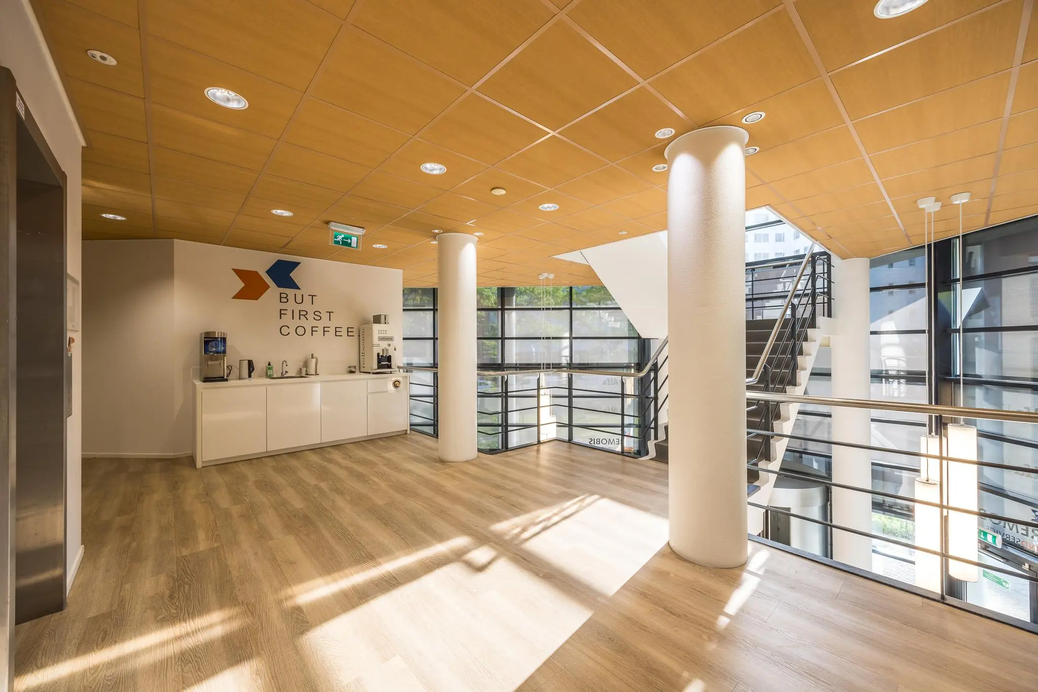 Moderne kantoorruimte met koffiehoek en trap, gelegen aan de Varrolaan.