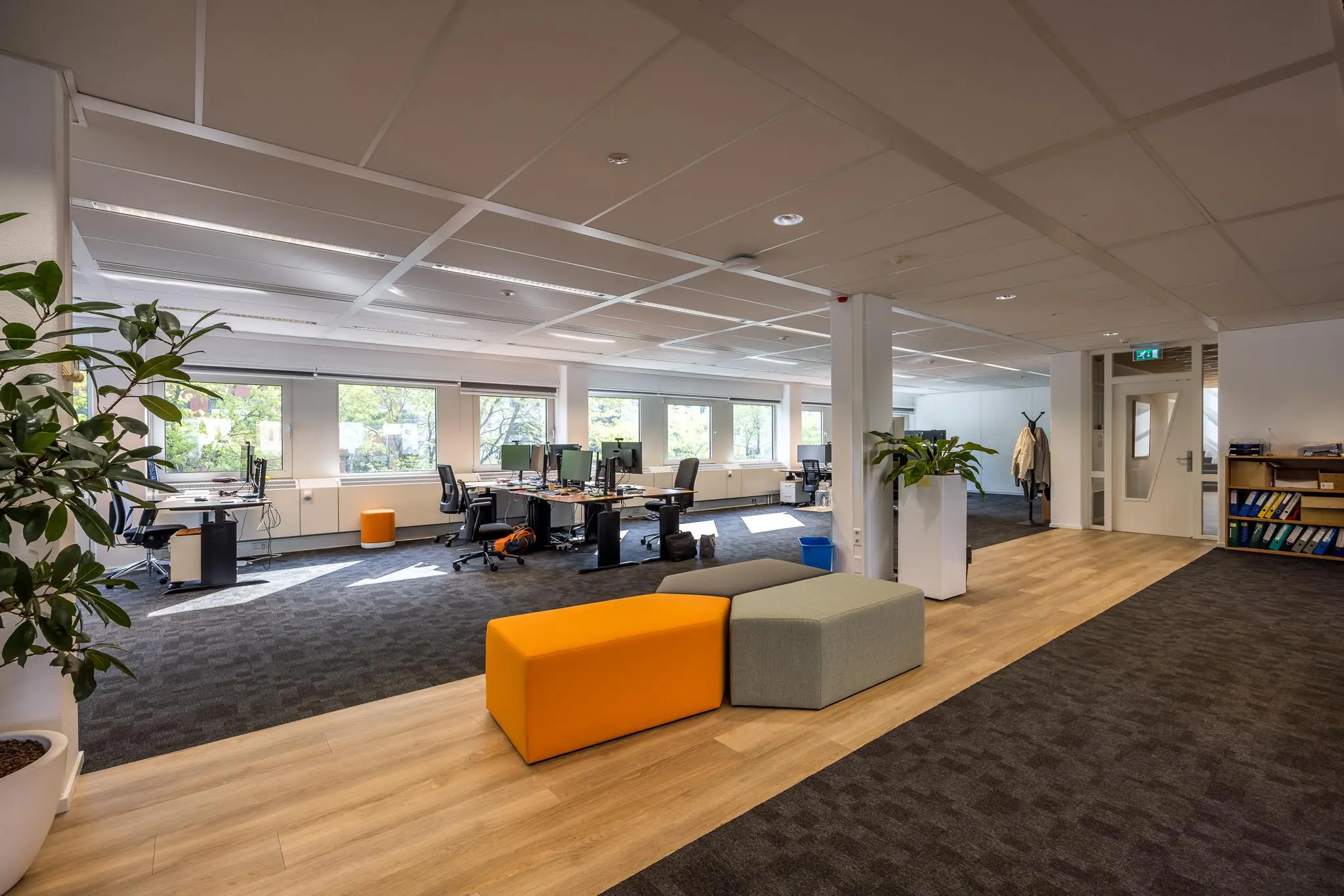 Modern en licht open kantoor aan de Varrolaan met werkplekken, loungezitjes en grote ramen.