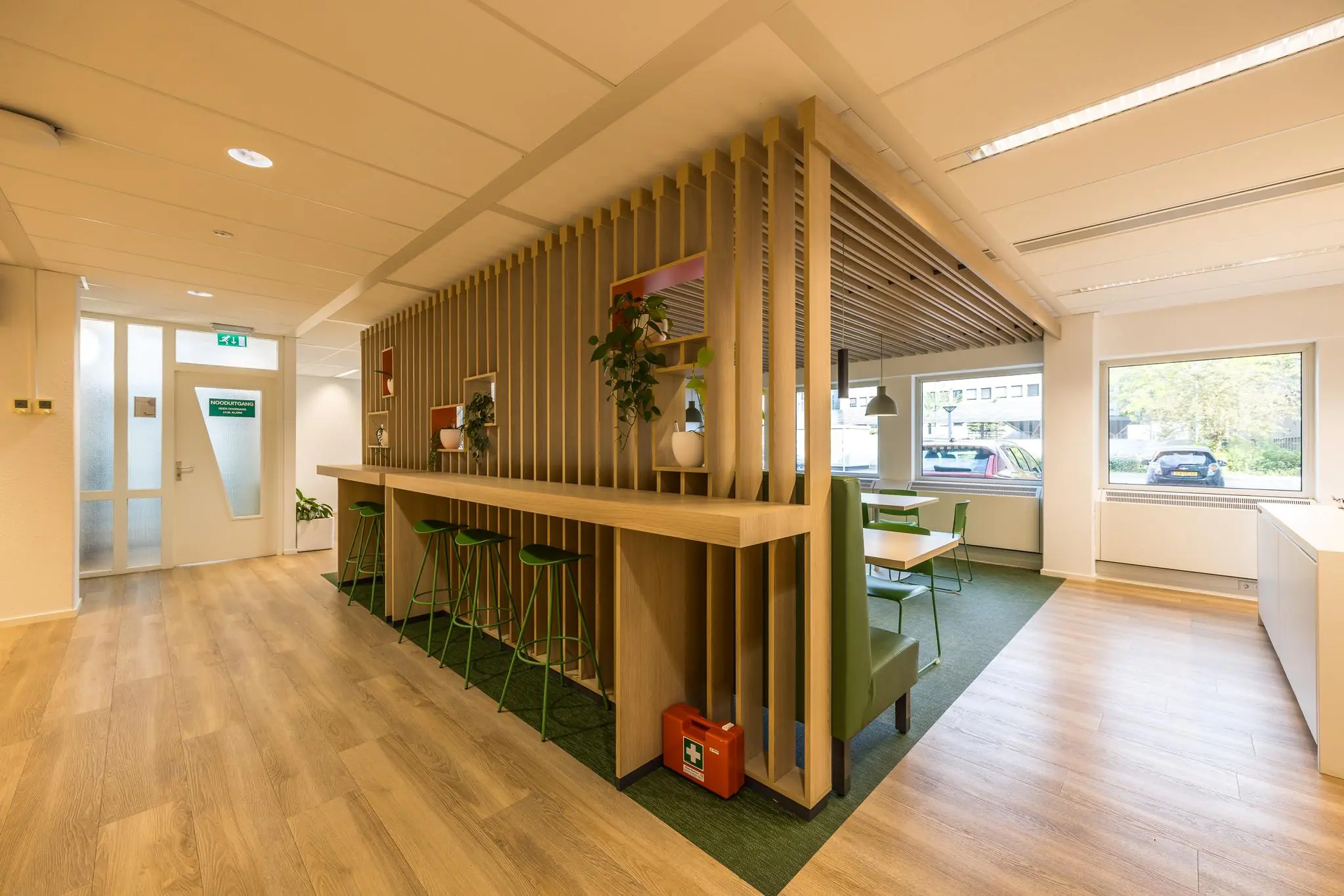 Moderne kantoorruimte aan de Varrolaan met houten afwerking, groene accenten en zitgelegenheid.