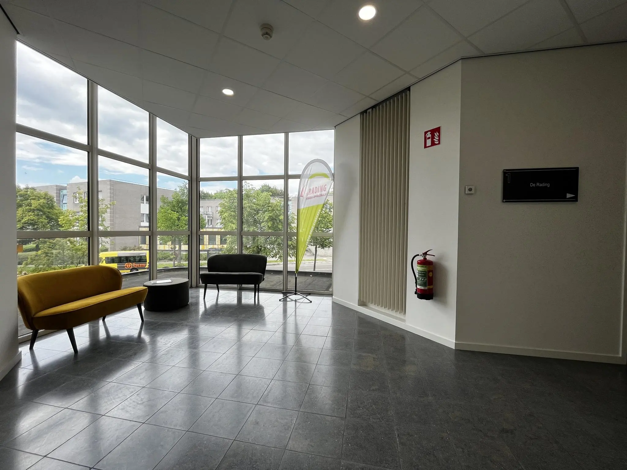 Wachtruimte met zitbanken en grote ramen in een modern kantoorgebouw aan de Vreeswijksestraatweg.
