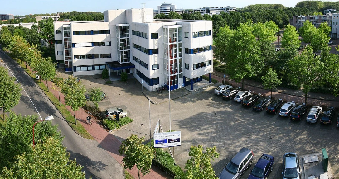 Kantoorpand aan de Vreeswijksestraatweg met parkeerterrein en omliggende bomen.