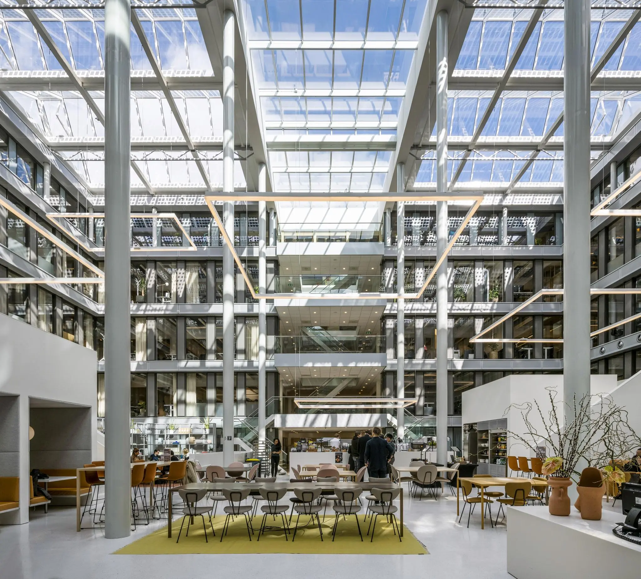 Licht en modern atrium van een kantoorgebouw aan de Mr. Treublaan met hoge glazen plafonds en open werk- en zitruimtes.
