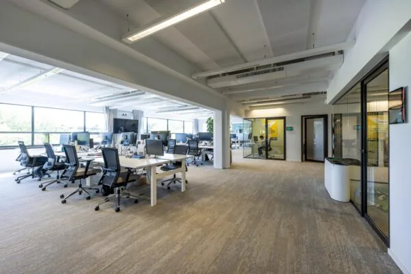 Modern en licht open kantoorinterieur aan de Mr. Treublaan met werkplekken en glazen vergaderruimtes.