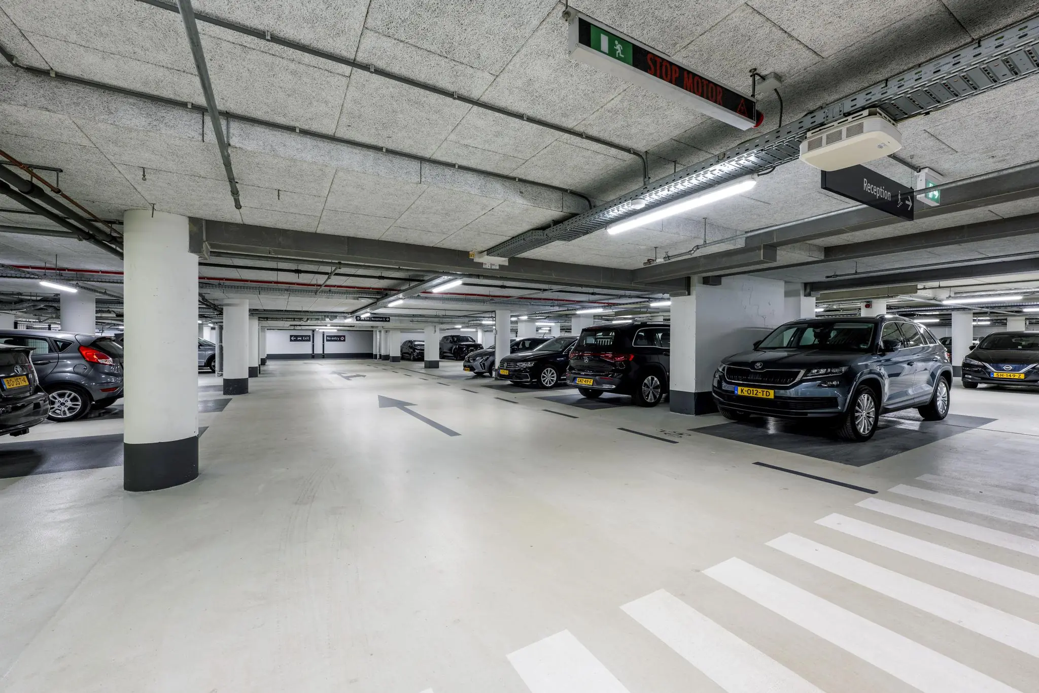 Ondergrondse parkeergarage aan de Mr. Treublaan met geparkeerde auto's en duidelijke bewegwijzering.