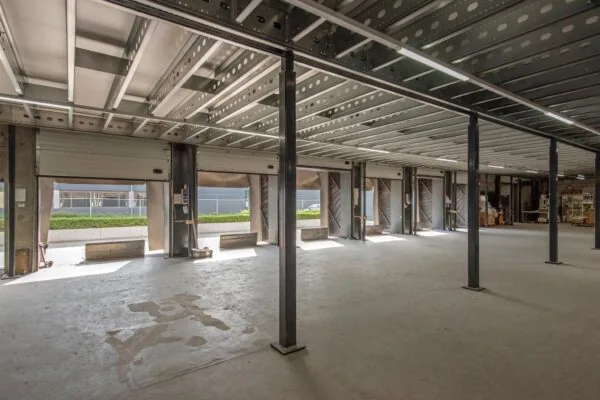 Leegstaande industriële ruimte aan de Limpergstraat met openstaande laaddeuren en zicht op de buitenzijde.