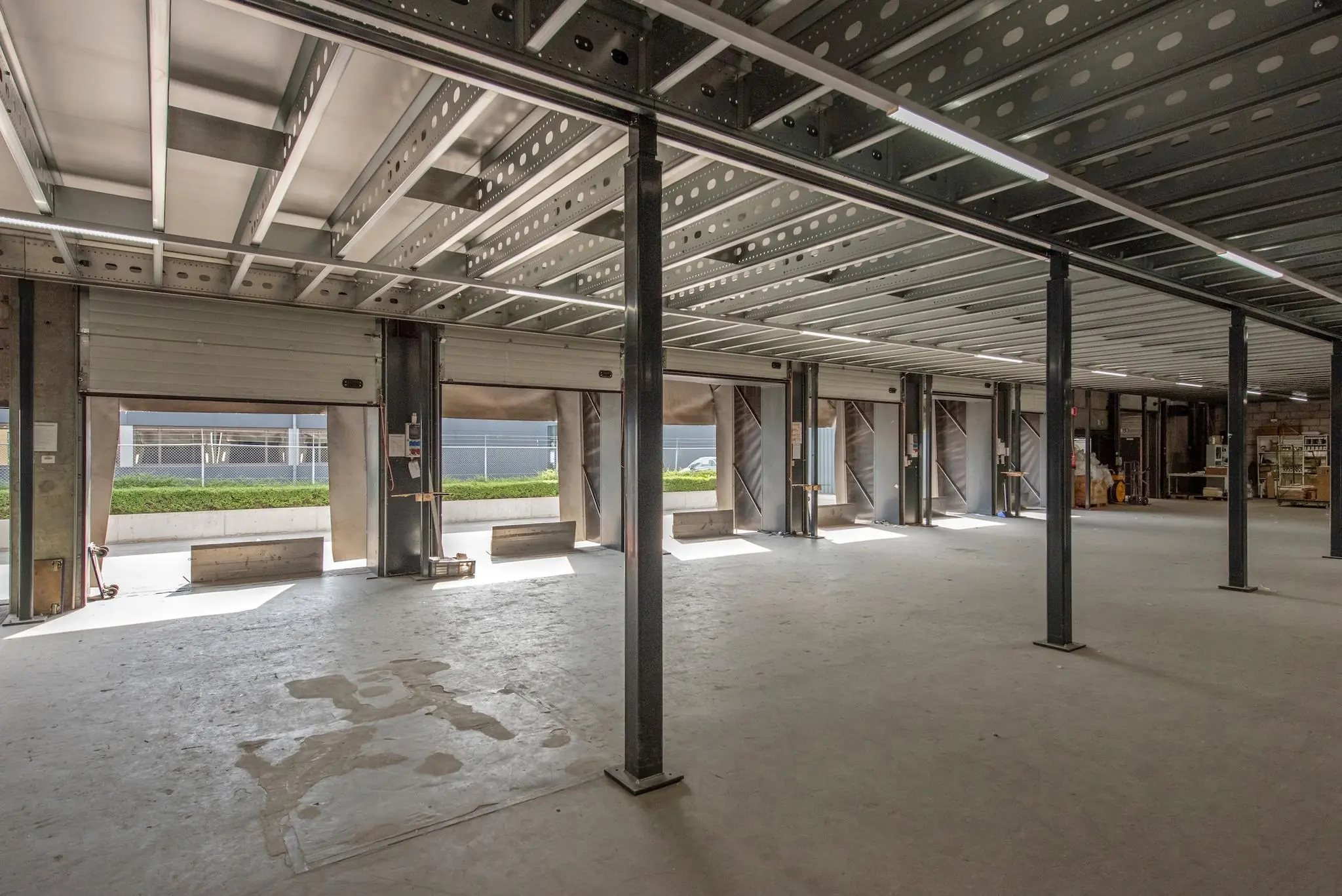 Leegstaande industriële ruimte aan de Limpergstraat met openstaande laaddeuren en zicht op de buitenzijde.