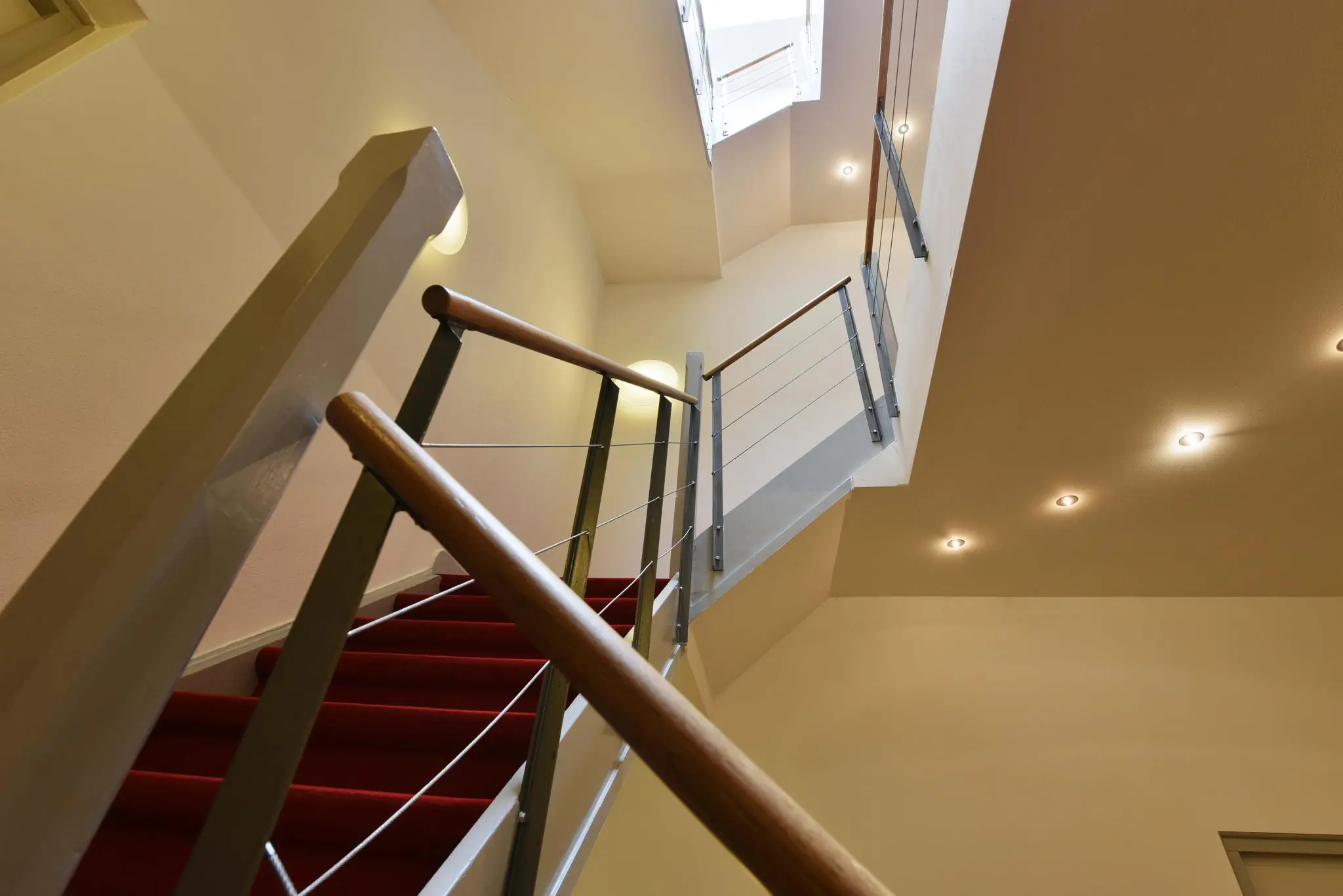 Moderne trap met rode loper en metalen leuning in het trappenhuis van een gebouw aan de Maliesingel.