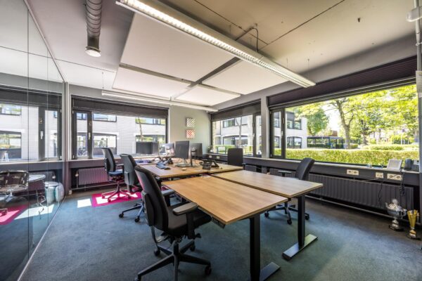 Modern kantoor met meerdere werkplekken en grote ramen aan de Burgemeester Verderlaan.