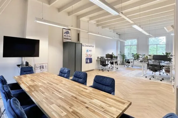 Modern licht kantoorinterieur aan de Paulus Potterstraat met een vergadertafel, open werkplekken en grote ramen.