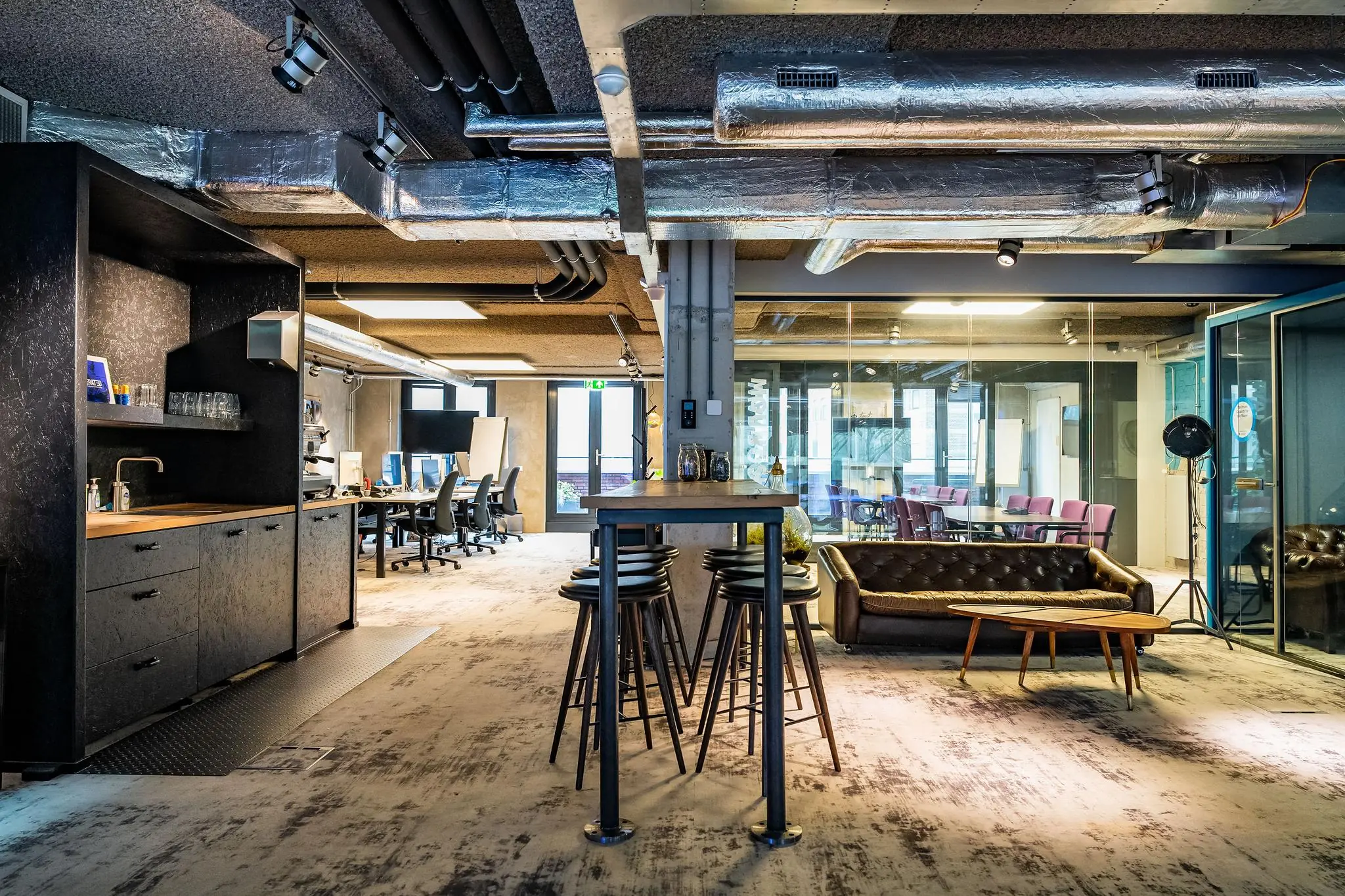 Modern ingerichte kantoorruimte aan de Wibautstraat met open werkplekken, vergaderruimte, loungehoek en koffiebar.