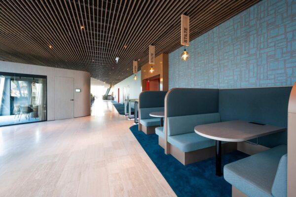 Moderne kantoorruimte aan de David Ricardostraat met stille werkplekken in blauwe zitbanken en houten afwerking.