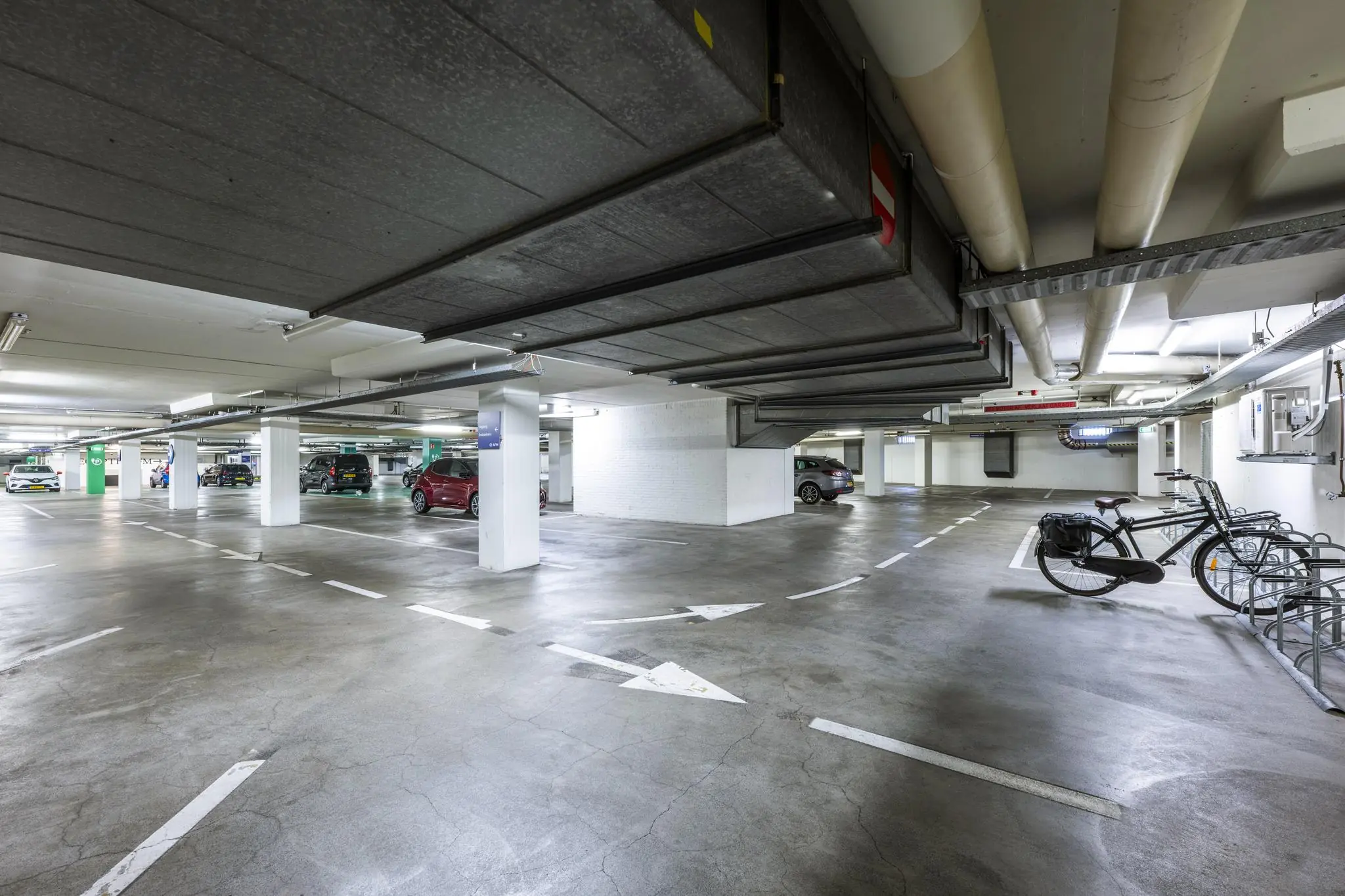 Ondergrondse parkeergarage aan de Vijzelgracht met geparkeerde auto's en fietsenrekken.
