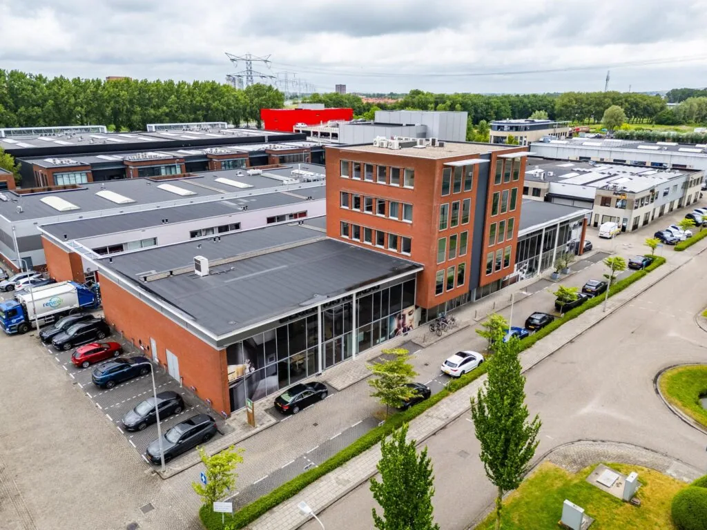 Luchtfoto van een modern bedrijfsverzamelgebouw aan de Cornusbaan met parkeerplaatsen en omliggende kantoren.