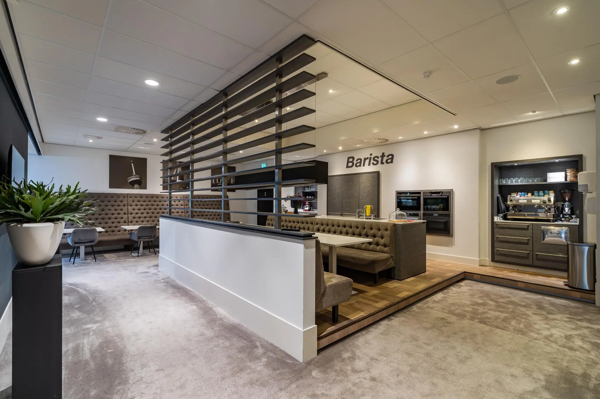 Moderne en sfeervolle barista-hoek met zitgedeelte en koffiemachine in een kantoorruimte aan de Cornusbaan.