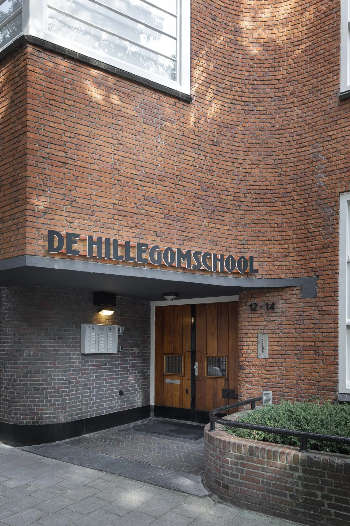 Ingang van De Hillegomschool aan de Hillegomstraat met een houten deur en bakstenen gevel.