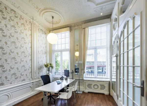Luxe kantoorruimte met klassieke ornamenten en uitzicht op het Concertgebouwplein.