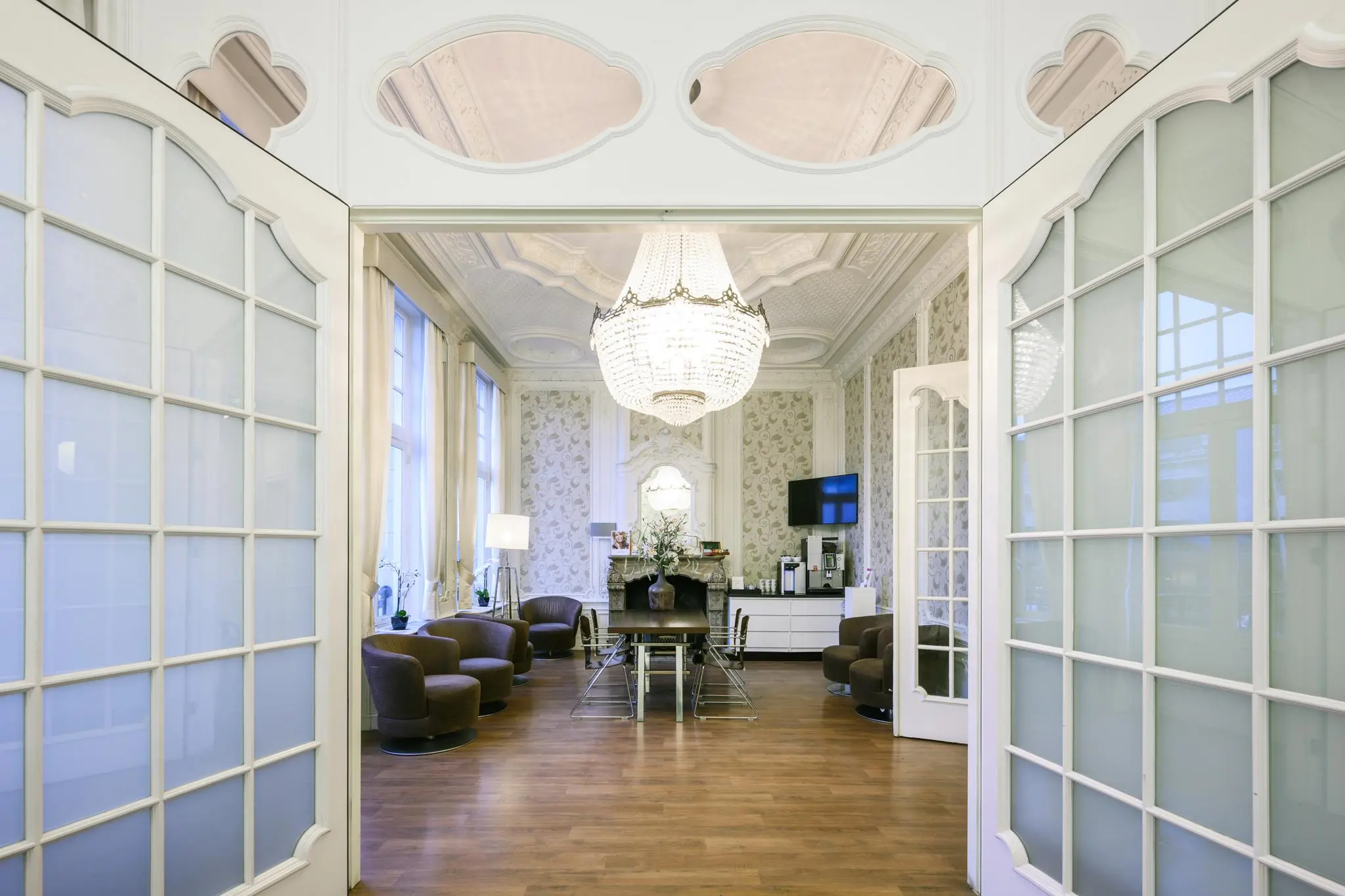 Stijlvolle ontvangstruimte aan het Concertgebouwplein met klassieke inrichting, kroonluchter en moderne zithoeken.