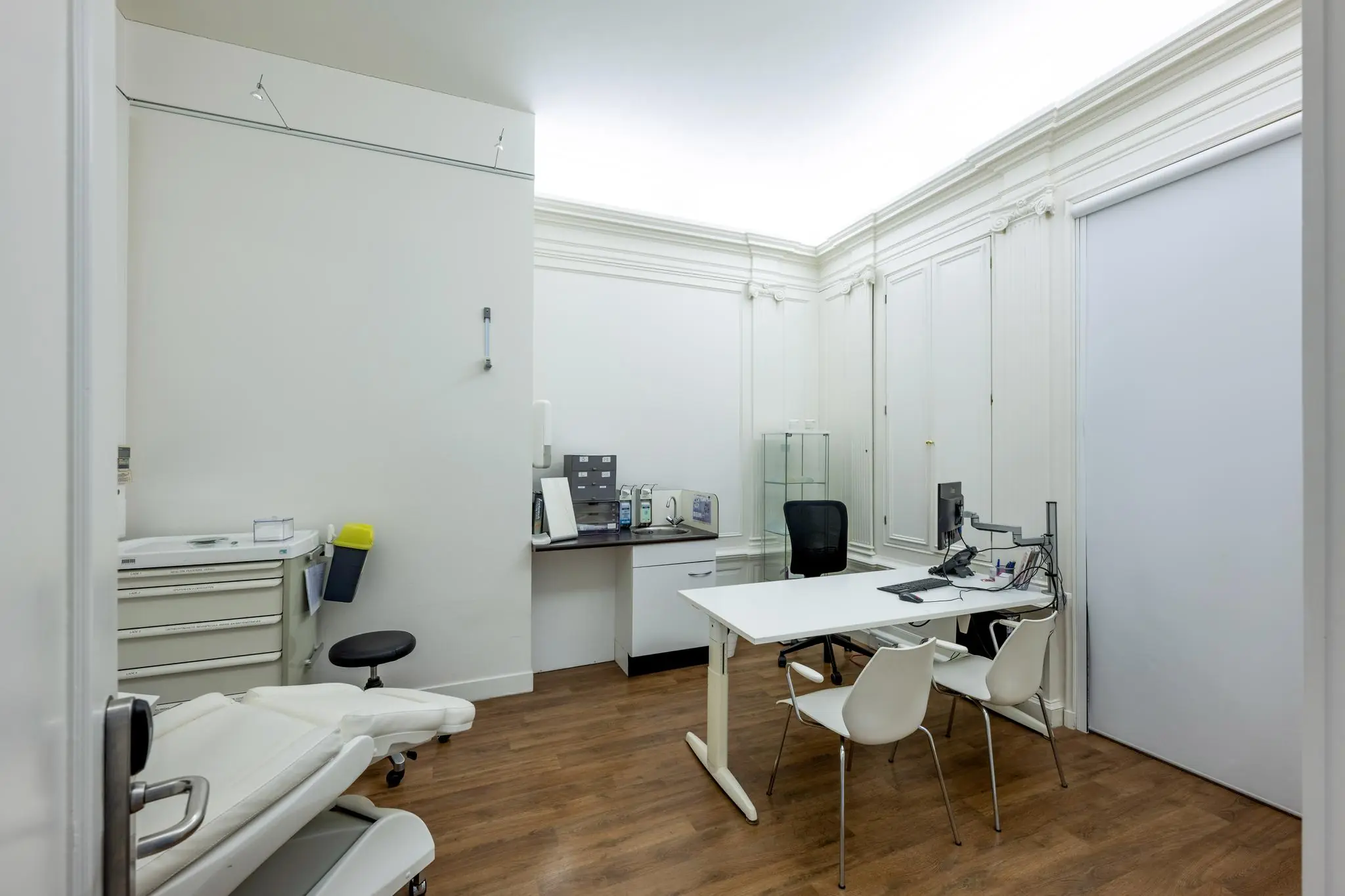 Moderne en nette dokterspraktijk met bureau, behandelstoel en medische apparatuur aan het Concertgebouwplein.