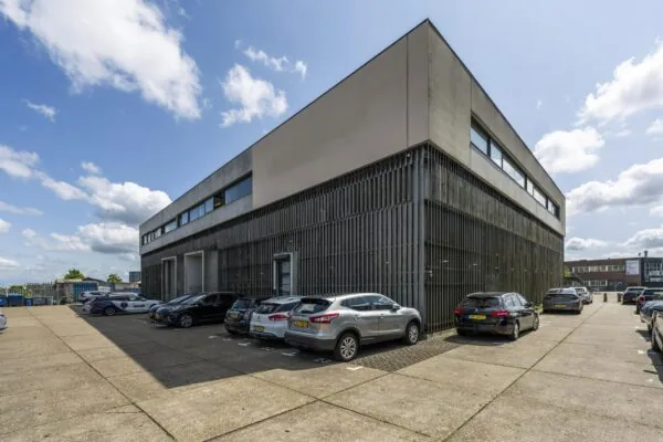 Modern kantoorgebouw aan de Johan van Hasseltweg met geparkeerde auto's op een ruime parkeerplaats.