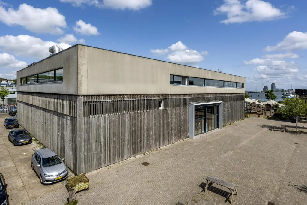 Moderne bedrijfs- of atelierruimte aan de Johan van Hasseltweg in Amsterdam, met houten gevelbekleding en uitzicht op het IJ.