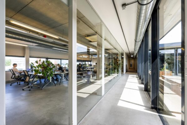 Moderne kantoorruimte aan de Johan van Hasseltweg met glazen wanden, open werkplekken en veel natuurlijk licht.