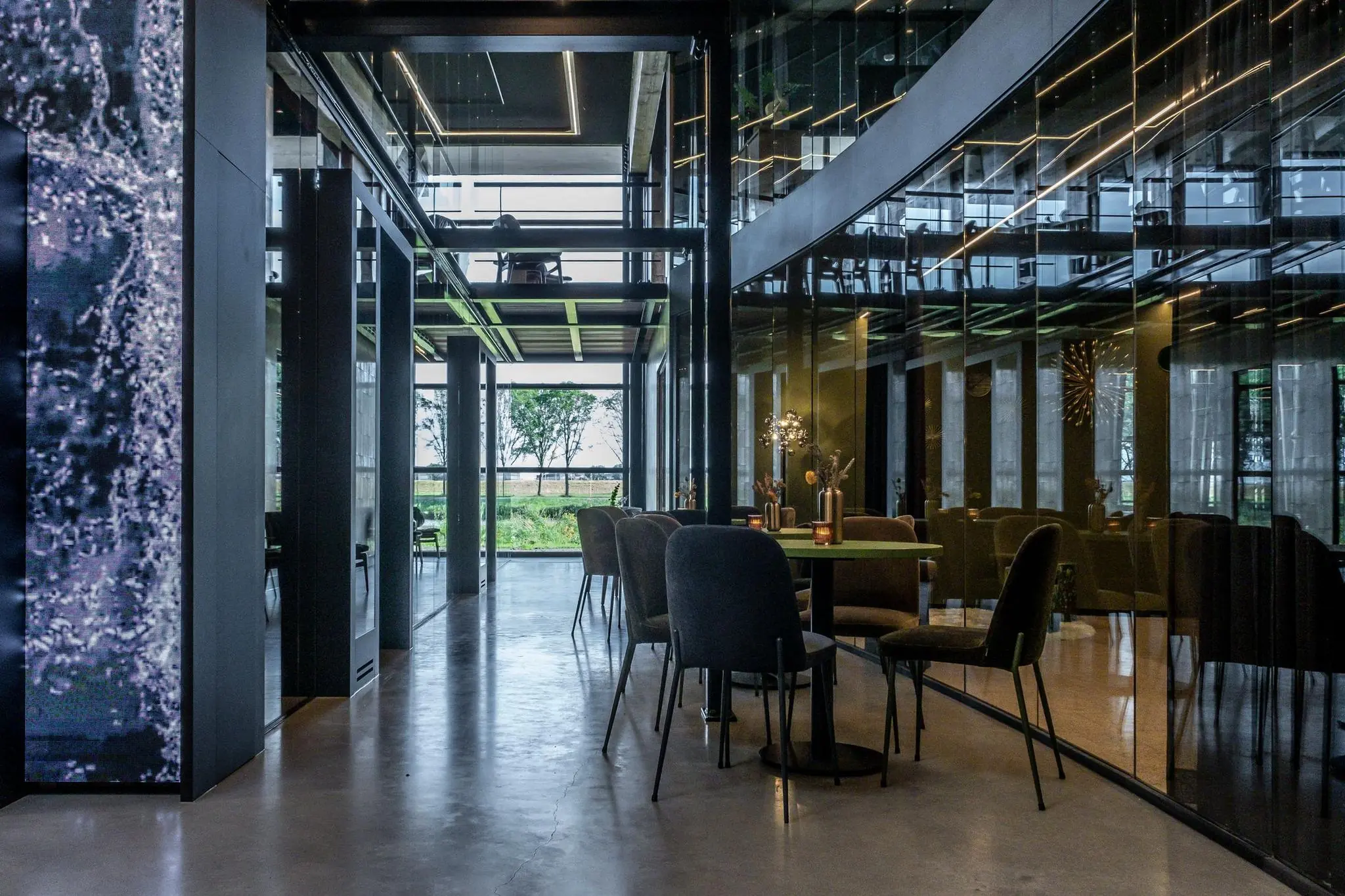 Modern interieur van een glazen kantoorpand aan de Plaatweg met uitzicht op een groene buitenomgeving.