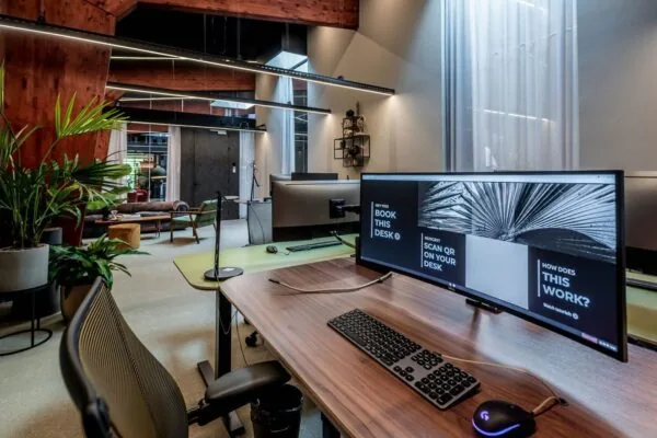 Moderne flexwerkplek met een groot gebogen scherm in een stijlvol ingericht kantoor aan de Plaatweg.