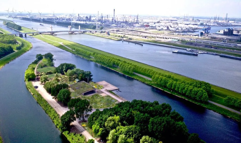 Luchtfoto van de Plaatweg nabij een waterrijk industriegebied met brug, kanalen en groene oevers.