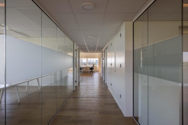 Moderne kantoorruimte aan de Overschiestraat met glazen wanden en uitzicht op de stad.