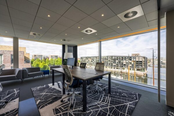 Modern kantoor met grote ramen en uitzicht op de Krijn Taconiskade en aangemeerde boten in een jachthaven.