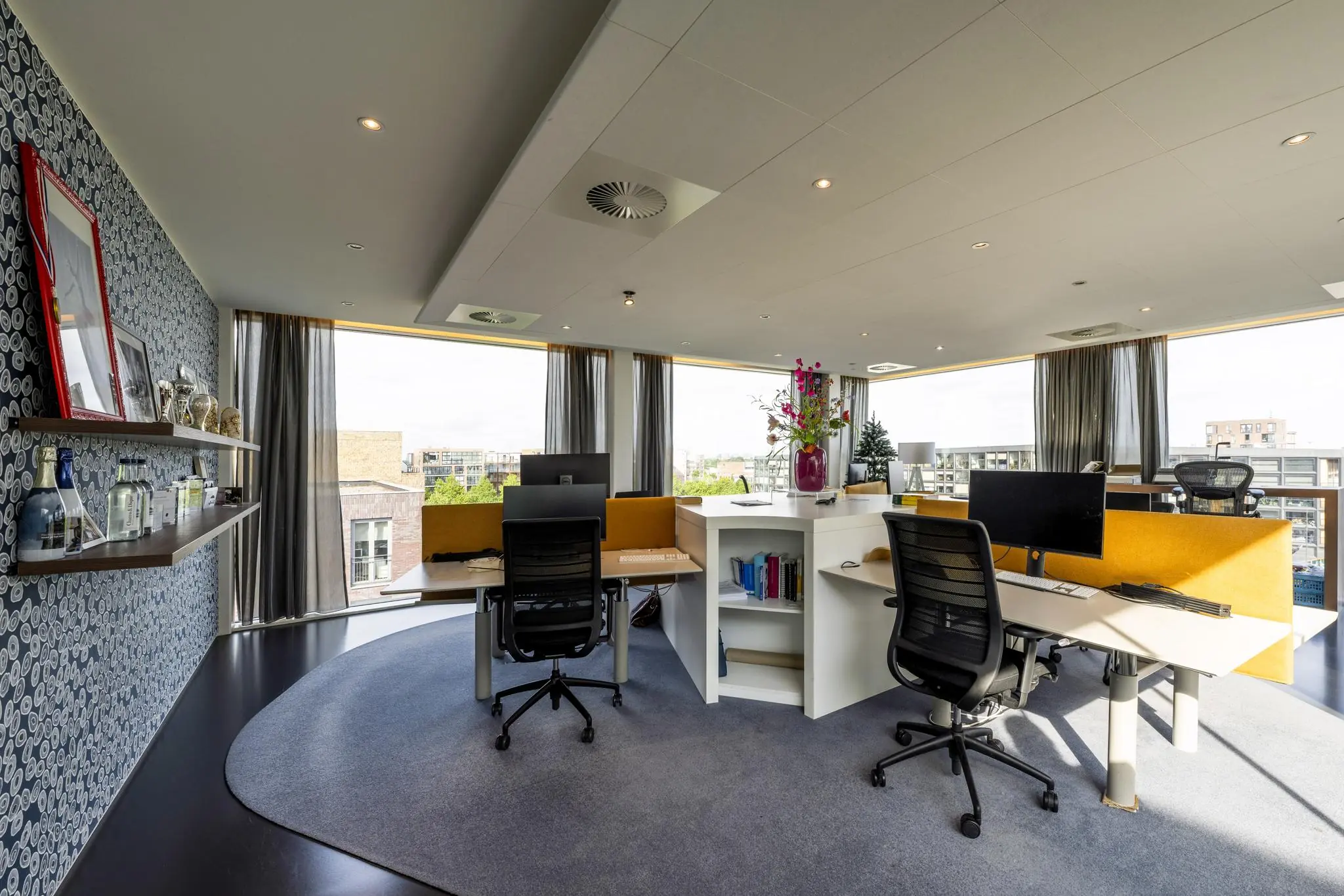 Modern kantoor met ruime werkplekken, grote ramen en uitzicht op de Krijn Taconiskade.