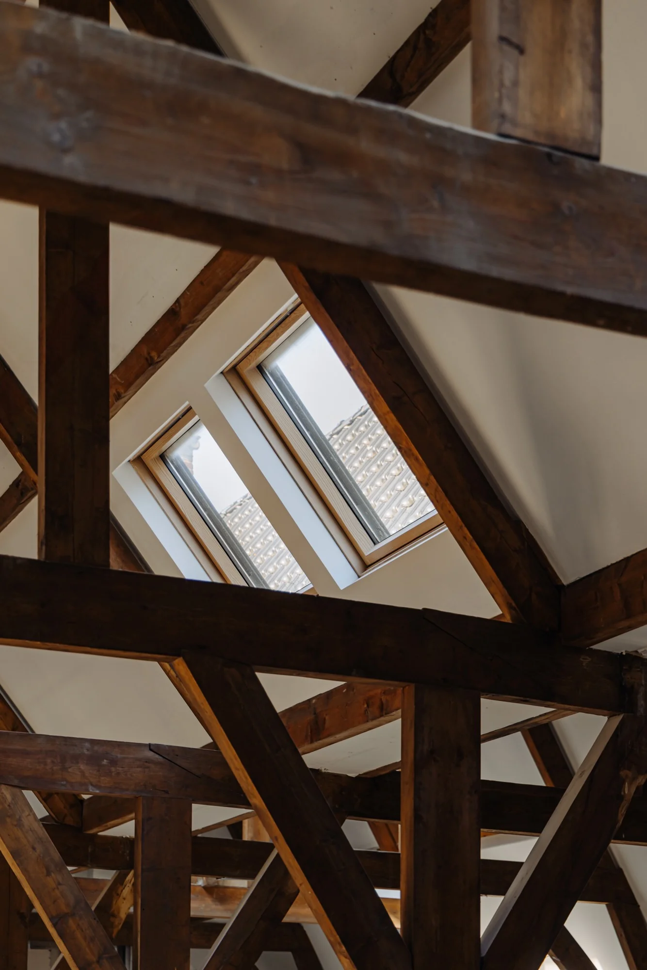 Houten dakconstructie met zicht op twee dakramen in een pand aan de Leidseweg.