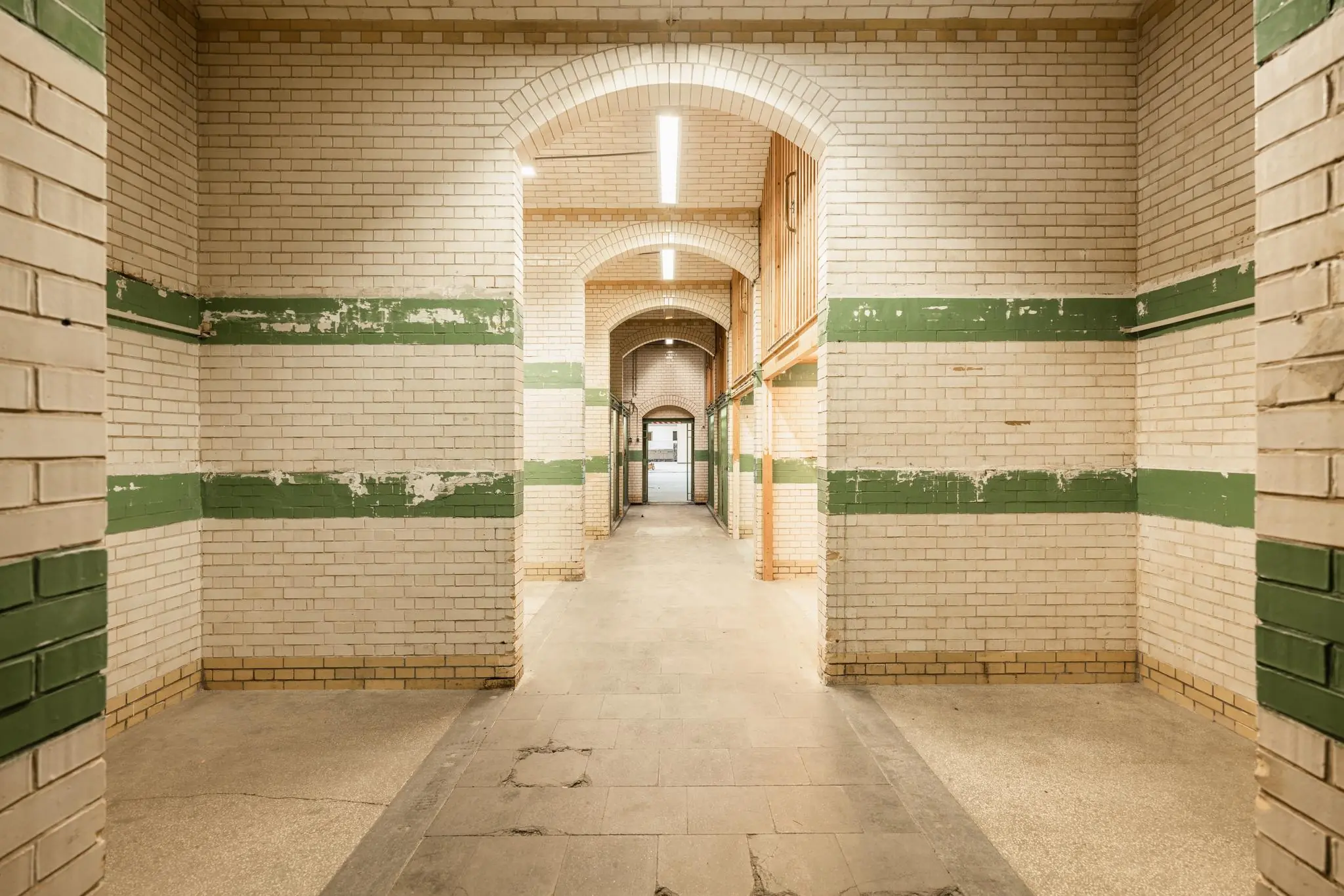 Geverfde stenen gang in het gebouw aan de Leidseweg, met witte tegels en groene strepen.