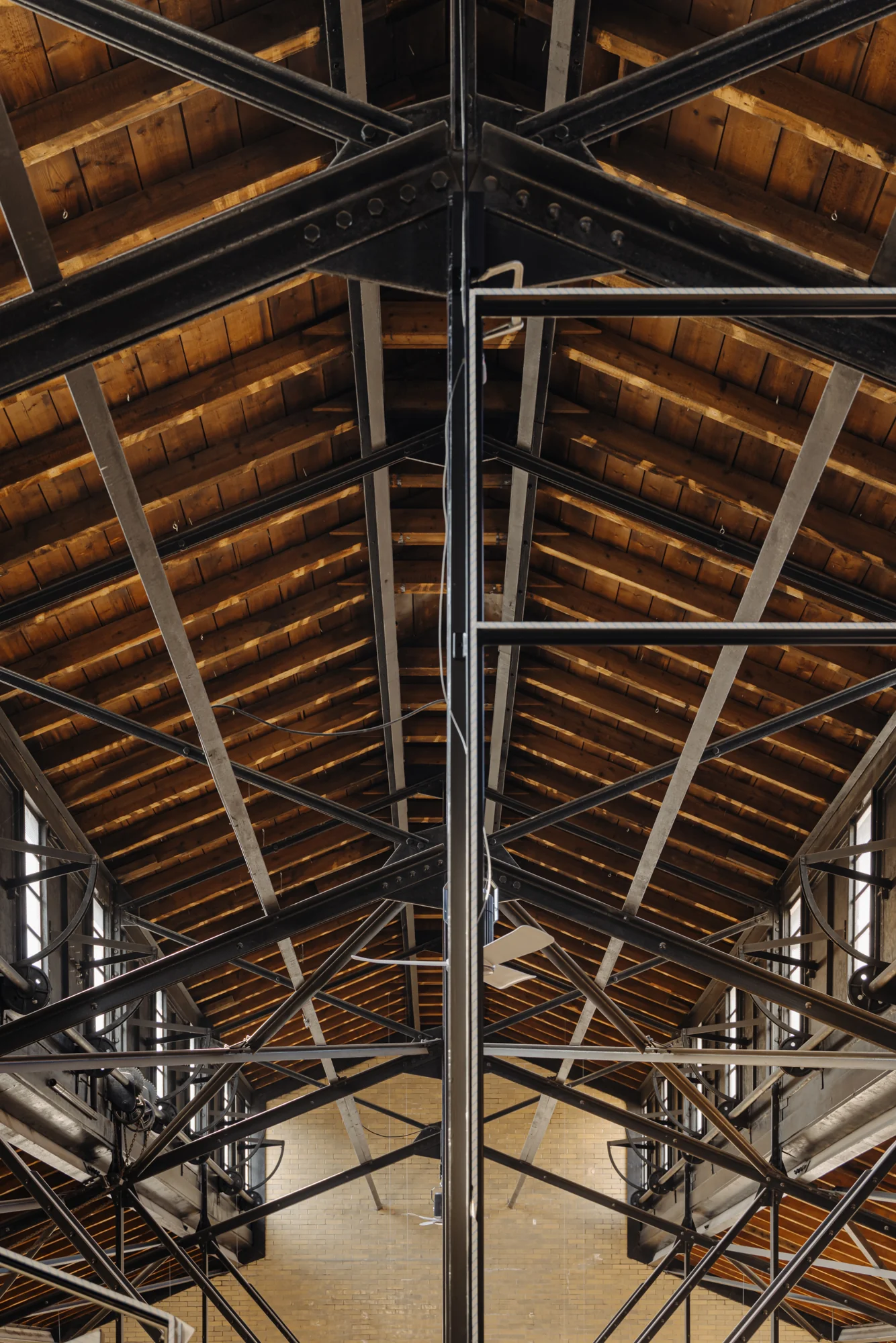 Interieur van een industriële loods aan de Muntkade met houten dakconstructie en stalen spanten.