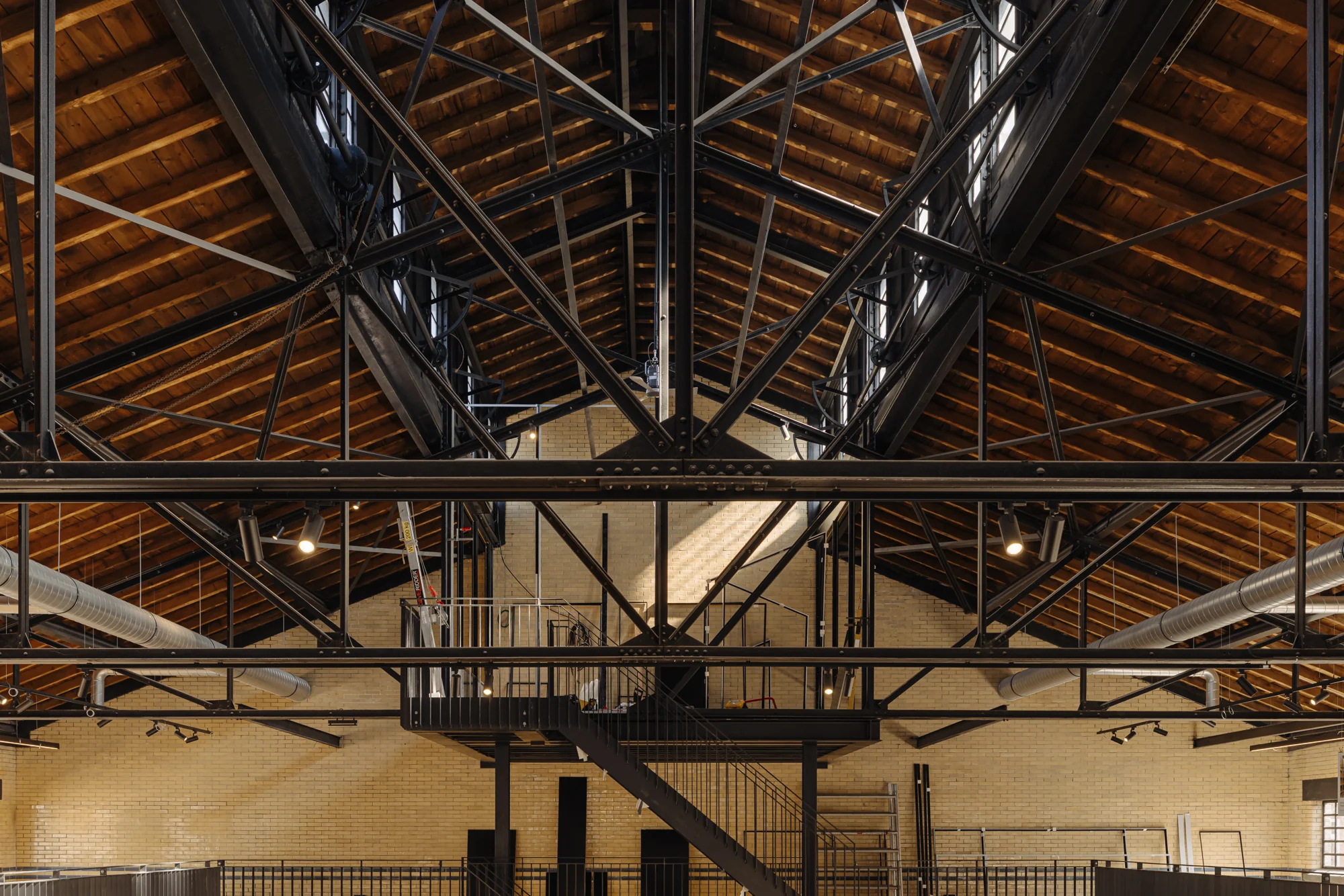Industriële houten dakconstructie met stalen spanten in een gerenoveerd gebouw aan de Muntkade.