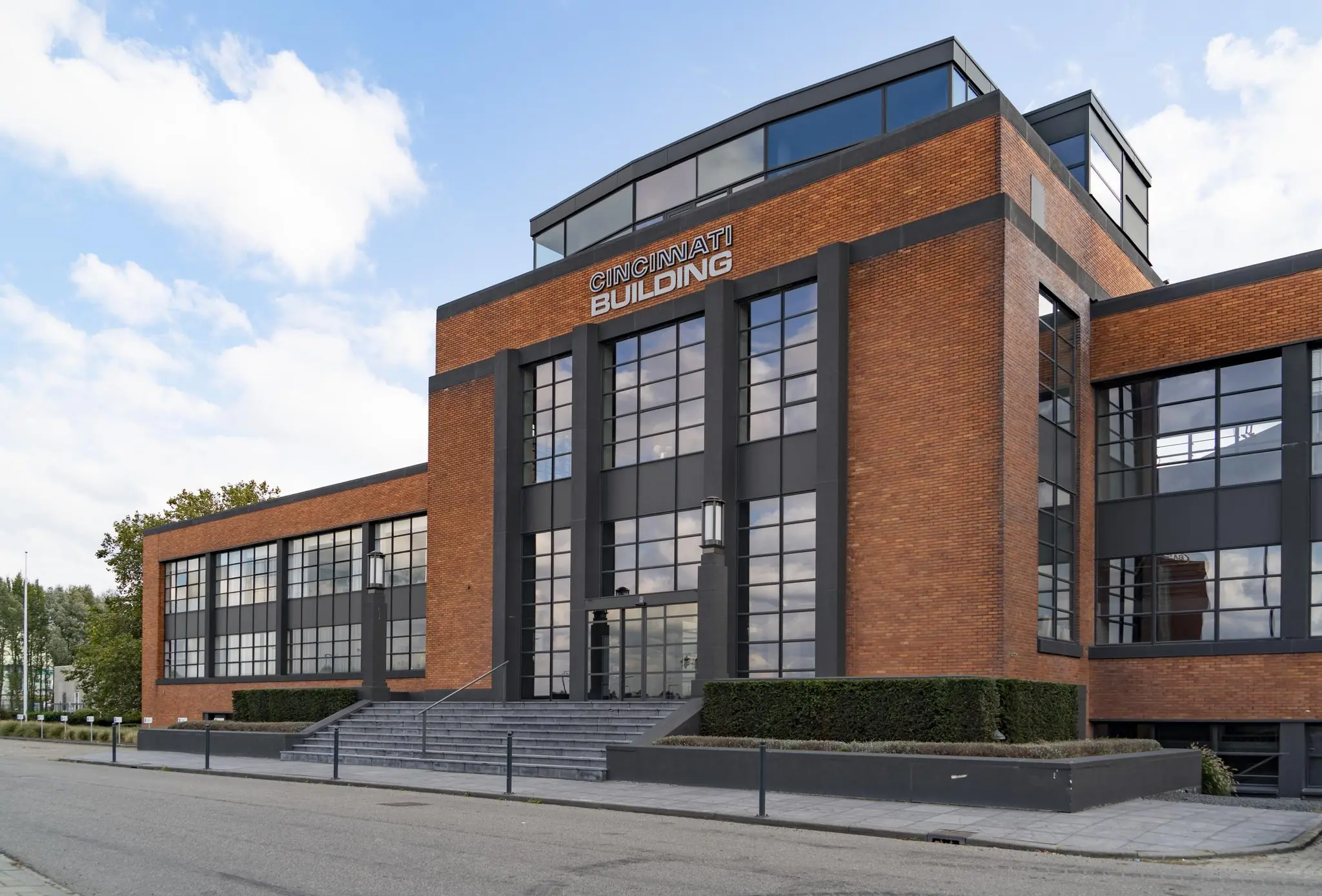 Vooraanzicht van het Cincinnati Building aan de Schiedamsedijk met een moderne bakstenen gevel en grote ramen.
