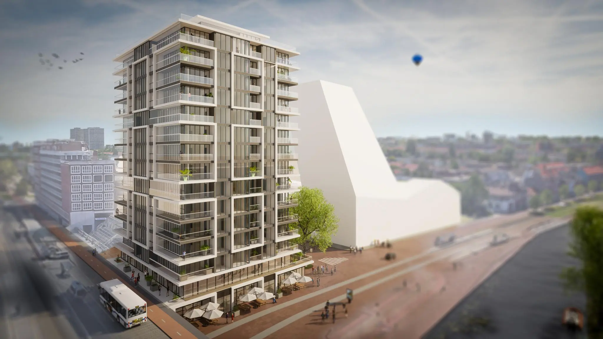 Moderne woontoren met glazen gevel en balkons aan het Stationsplein, gelegen langs een waterpartij met wandelpromenade.